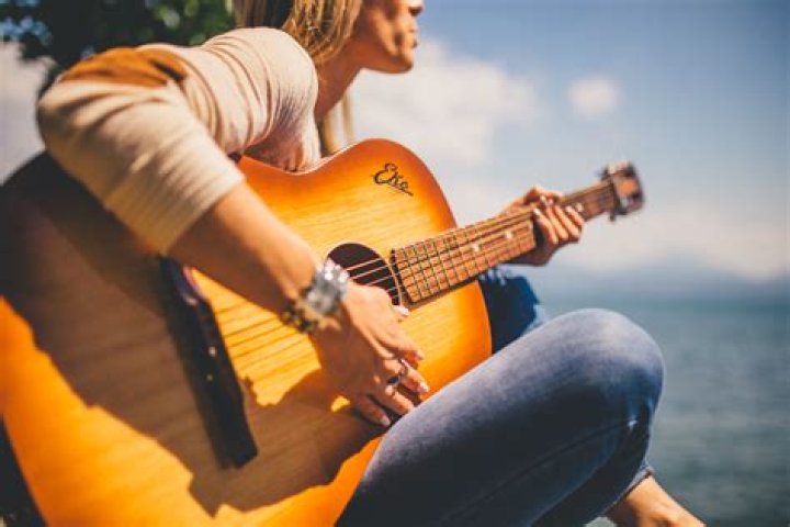 a woman playing a guitar on stage at a concert